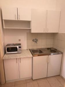 a small kitchen with a sink and a microwave at Apartment Enna in Kaštela