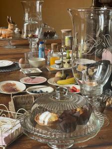 une table remplie de vaisselle et de verres et une assiette de nourriture dans l'établissement Chateau du Grand Lucay, à Bourbon-lʼArchambault