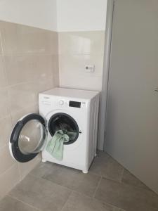 een wasmachine en droger in een badkamer met een wasmachine bij Casa luminoasa cu parcare gratuita la proprietate in Dumbrăviţa