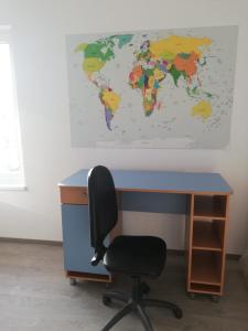 een bureau en een stoel met een kaart aan de muur bij Casa luminoasa cu parcare gratuita la proprietate in Dumbrăviţa