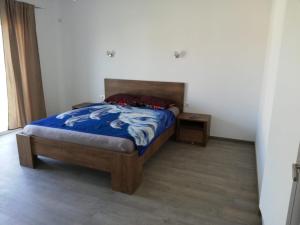 1 dormitorio con 1 cama con edredón azul en Casa luminoasa cu parcare gratuita la proprietate en Dumbrăviţa