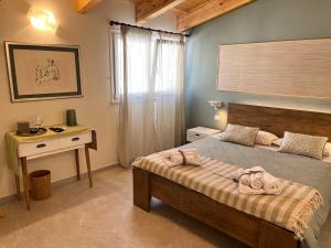 a bedroom with a bed and a desk and a window at B&b AlgueRoof in Alghero
