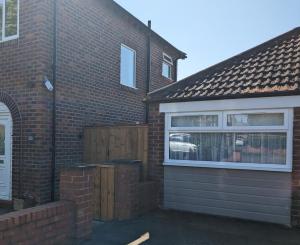 a brick house with a garage and a fence at The Guest Place in Redcar