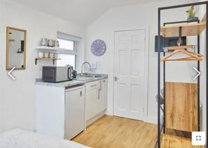 Una cocina blanca con fregadero y encimera. en The Guest Place, en Redcar