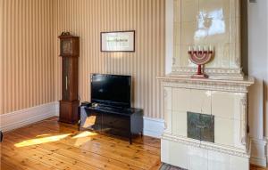 uma sala de estar com televisão e um relógio avô em Amazing Home In Lindesberg With House Sea View em Lindesberg