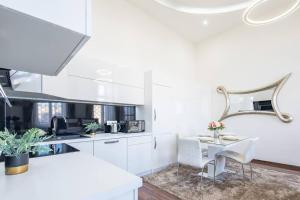 a kitchen with white cabinets and a table with chairs at Opera Luxury Studio Apartment in Budapest