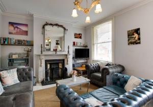 a living room with two couches and a fireplace at Upper Nestleton Maisonette in Swanage