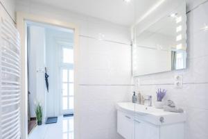 Baño blanco con lavabo y espejo en Opera Luxury Studio Apartment, en Budapest