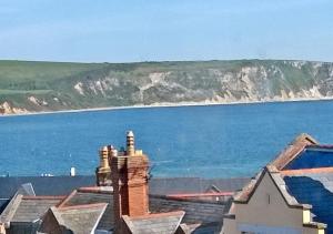 a view of the ocean from the roof of a house at Upper Nestleton Maisonette in Swanage