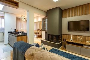 a living room with a fireplace and a tv at Apartamento Villaggio Del Veneto 1 dorm by Achei in Canela