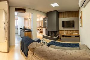 a living room with a couch and a tv at Apartamento Villaggio Del Veneto 1 dorm by Achei in Canela