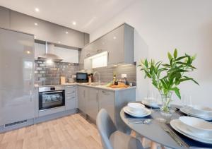 uma cozinha com uma mesa e cadeiras numa cozinha em Victoria Sands em Swanage
