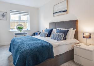 um quarto com uma cama grande e um cobertor azul em Victoria Sands em Swanage