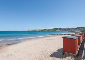 uma praia com uma fila de latas de lixo em Victoria Sands em Swanage