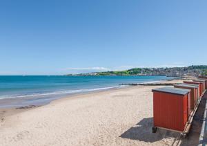 a beach with a row of trash cans on it at Victoria Sands in Swanage