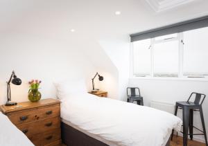 1 dormitorio con 2 camas y ventana en Trinity Terrace, en Weymouth