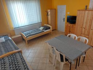 カジンツバルツィカにあるCOLLINGO Belvárosi Szállásのベッド、テーブル、椅子が備わる客室です。