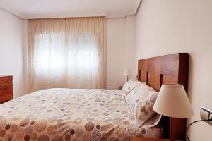 um quarto com uma cama grande e um candeeiro em Acogedor piso cerca de la playa em Ceuta