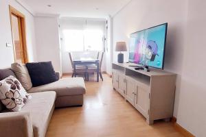 un soggiorno con divano e TV a schermo piatto di Acogedor piso cerca de la playa a Ceuta