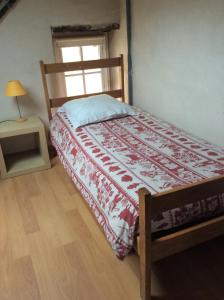 a bedroom with a bed with a red and white blanket at Chambres d'hôtes au calme 