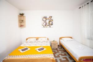 Habitación con 2 camas individuales y paredes blancas. en Apartments Jelena Ulcinj en Ulcinj
