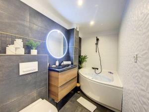 a bathroom with a sink and a tub and a mirror at Évasion Parfaite in Chamonix +9 photos