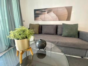 uma sala de estar com uma mesa de vidro e um sofá em Appartement les pieds dans l'eau em Mohammedia