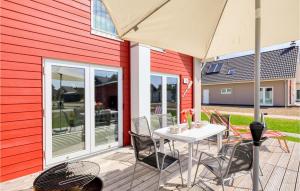 Un patio con una mesa y sillas y una sombrilla. en Heimathafen, en Büsum