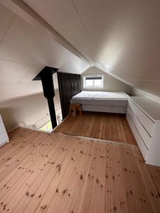 a room with a bed and a wooden floor at Midnattsol rom og hytter in Bleik