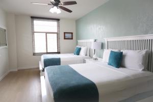 a bedroom with two beds and a ceiling fan at Hotel Carmel Santa Monica in Los Angeles