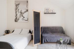 une chambre avec un lit, une chaise et un miroir dans l'établissement Charmante maison contemporaine idéalement située, à Embrun