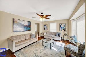 a living room with two couches and a ceiling fan at The Katerina Residence in Calumet City