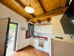 a kitchen with white cabinets and a ceiling with wooden ceilings at Villetta Starza in Marina di Camerota