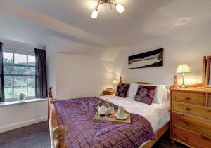 a bedroom with a bed with a tray on it at Rose Cottage in Chapel Stile