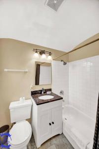 a bathroom with a toilet and a sink and a tub at The Katerina Residence in Calumet City