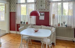 林德斯貝里的住宿－Amazing Home In Lindesberg With House Sea View，一间配备有白色桌椅的用餐室