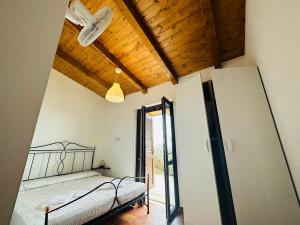 1 dormitorio con cama y techo de madera en Villetta Starza, en Marina di Camerota