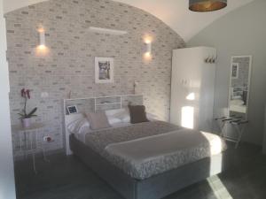 - une chambre avec un lit et un mur en briques dans l'établissement La Cornice dei Monti, à Tramonti