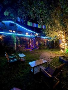a group of picnic tables in a yard at night at Mars Monkey Hostel & Cafe in Manāli