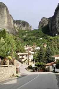 a winding road in a village with a mountain at Meteora's unique gem in Kastrákion