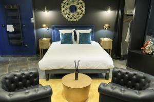 una camera da letto con un letto con pareti blu e due sedie di Le Legendary Spa, hypercentre avec sauna, balnéo et wifi par SOVALFI a Saint-Étienne