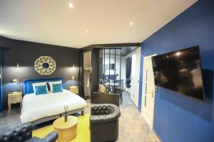 una camera da letto con un letto e una parete blu di Le Legendary Spa, hypercentre avec sauna, balnéo et wifi par SOVALFI a Saint-Étienne