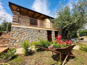 a house with a balcony and a bench and flowers at Villetta Starza in Marina di Camerota