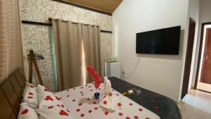 una camera da letto con un letto con cuori rossi sopra di Vila Flores Pousada a Serra do Cipo