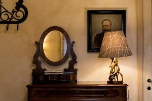 a table with a lamp and a mirror on a wall at Borghetto Poggio Bianco in Radicondoli