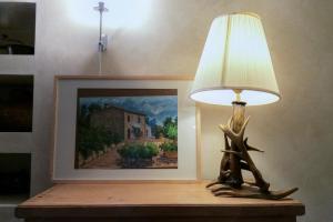 una lampada seduta su un tavolo accanto a un dipinto di Borghetto Poggio Bianco a Radicondoli