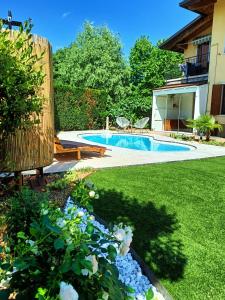 un patio con piscina y algunas flores en Picnic Room and Pool en Castelnuovo del Garda