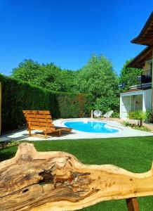 un cortile con piscina, panchina e tronchi di Picnic Room and Pool a Castelnuovo del Garda