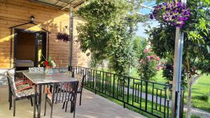 un patio con mesa, sillas y una valla en Room with private garden, en Shkodër