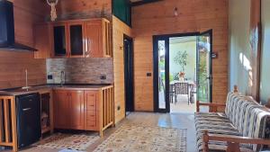 una cocina con armarios de madera y una puerta que conduce a un patio en Room with private garden, en Shkodër